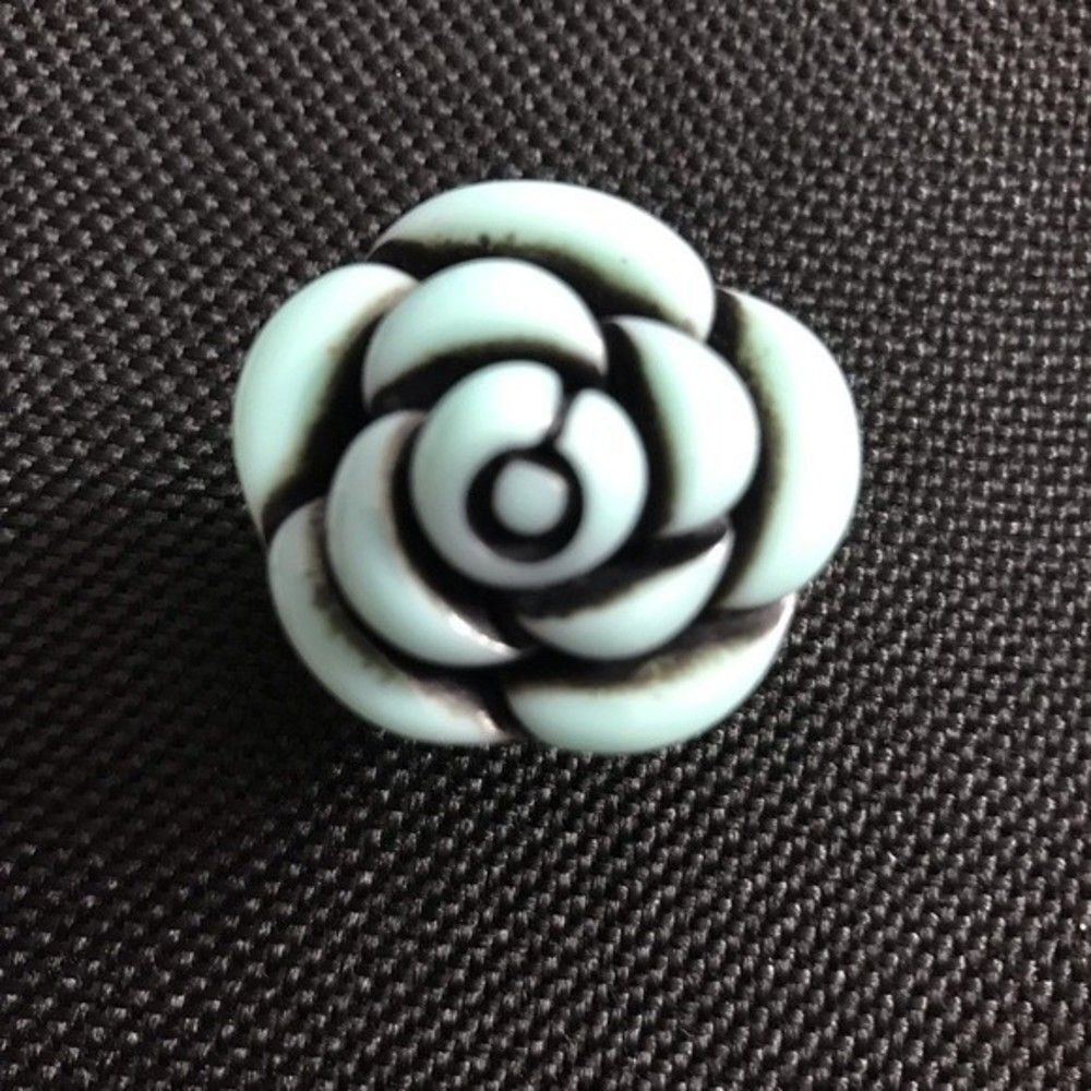 Black and light blue “rose ring” which has an adjustable ring band.